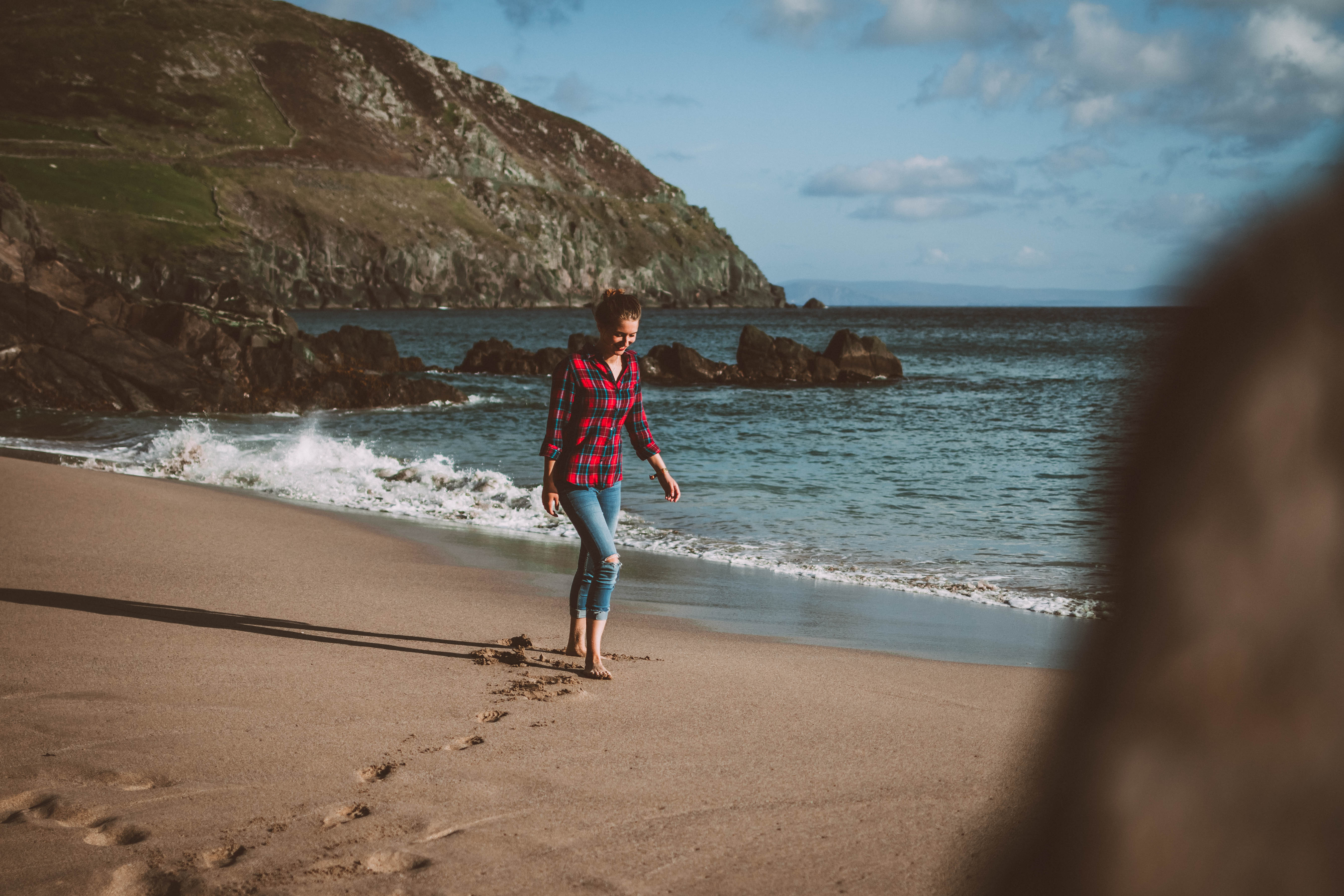 Frau am Strand an der Küste in Irland